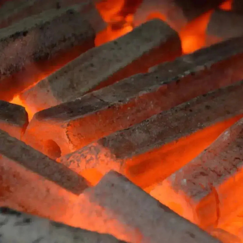 Glowing Fire Up! Cocoshell Charcoal Briquettes burning evenly, showcasing long-lasting heat and clean combustion.