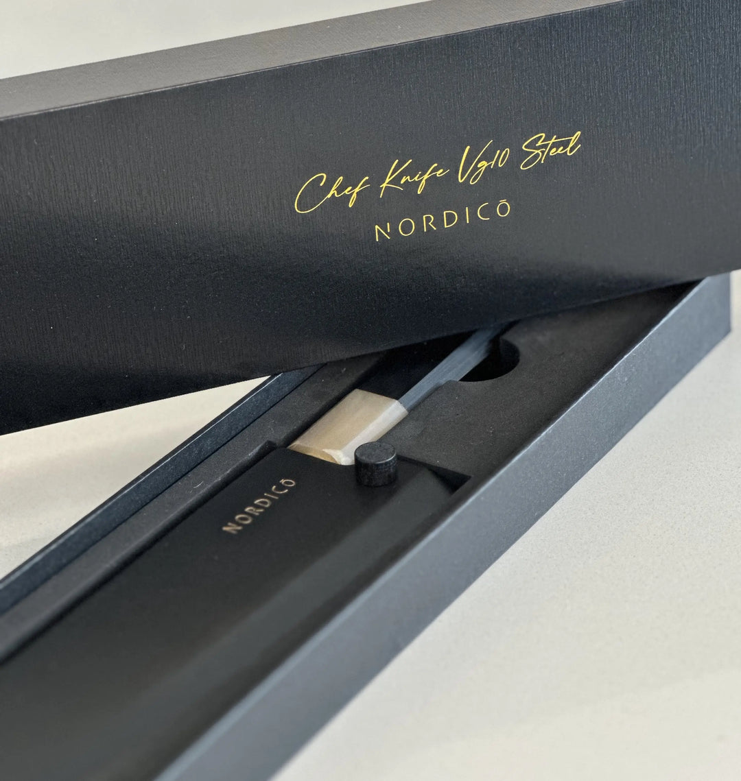 Opened Nordico VG10 Chef Knife premium gift box, displaying the black sheath and elegant design.