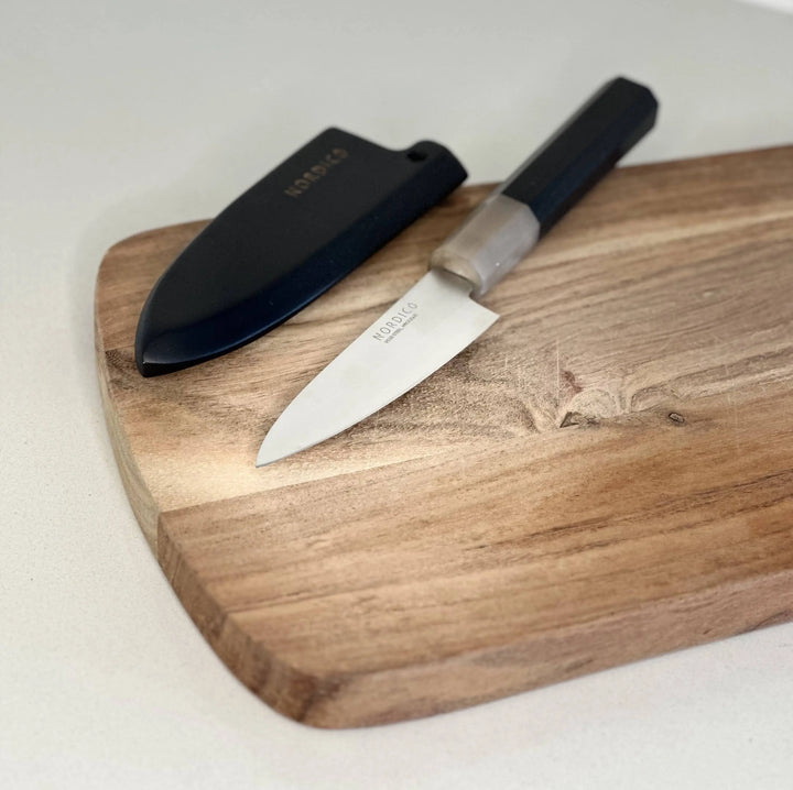 Nordico VG10 Paring Knife 4 inches with black wooden sheath displayed on a wooden cutting board, showcasing its elegant design.
