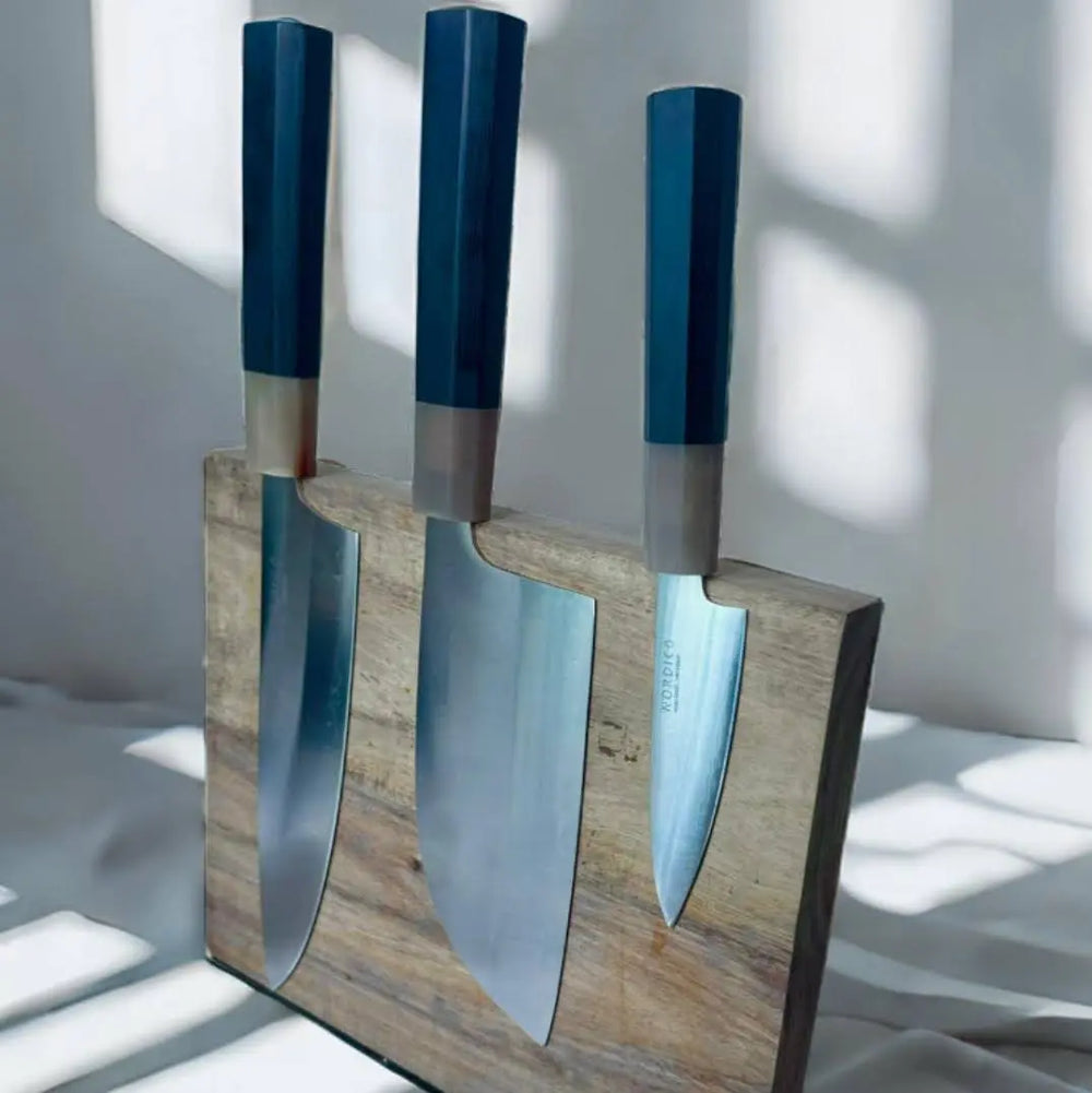 Set of three Nordico VG10 knives, including chef, cleaver, and paring knives, elegantly displayed on a magnetic wooden stand.