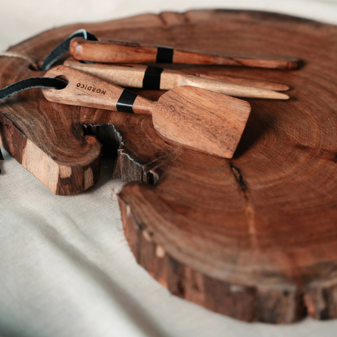 Nordico Cheese Board and Knives Close-Up – Acacia wood cheese board and knives in focus, highlighting the engraved Nordico branding and hand-finished design.