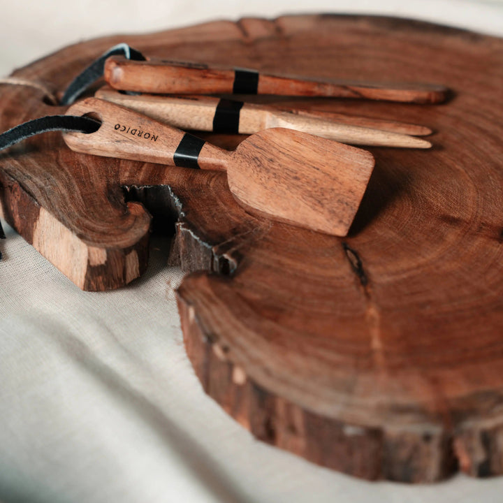 Nordico Cheese Board and Knives Close-Up – Acacia wood cheese board and knives in focus, highlighting the engraved Nordico branding and hand-finished design.