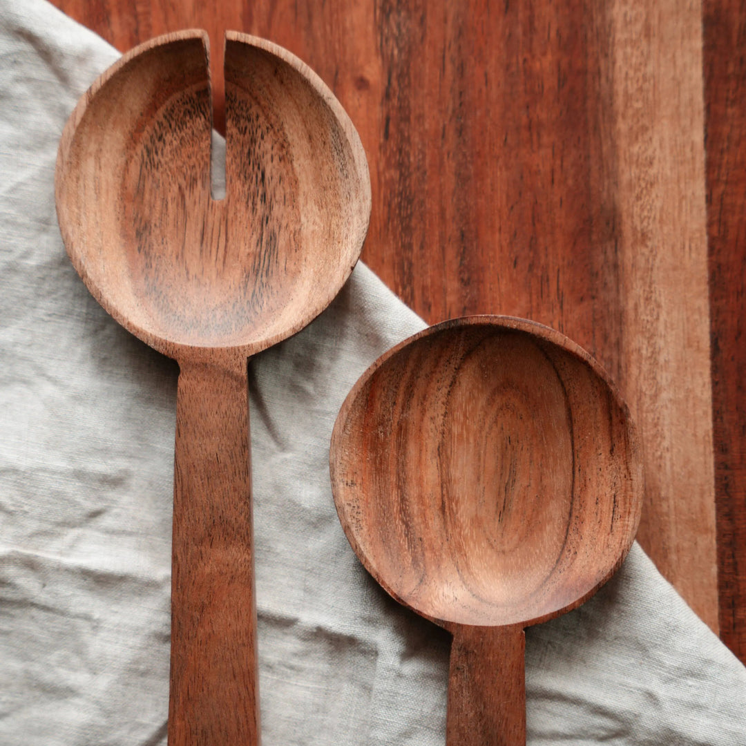 Nordico wooden salad servers placed inside a matching acacia wooden bowl, highlighting their natural finish.