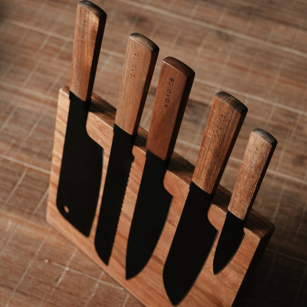 Nordico stainless steel knife set with acacia wood handles displayed on a matching magnetic wooden block.